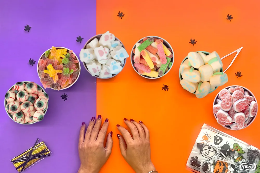 Manos preparando y cerrando una bolsa de chuches para Halloween